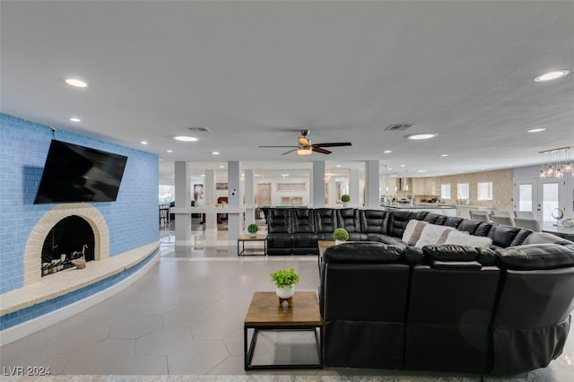 tiled living room with a fireplace and ceiling fan