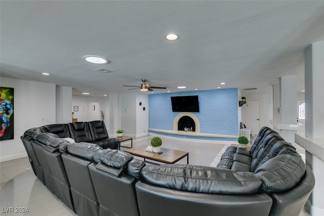 living room featuring a textured ceiling, ceiling fan, and a fireplace