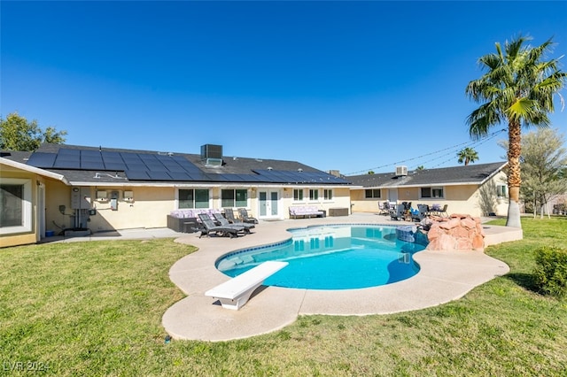 view of swimming pool featuring a diving board, central AC, a yard, and a patio area