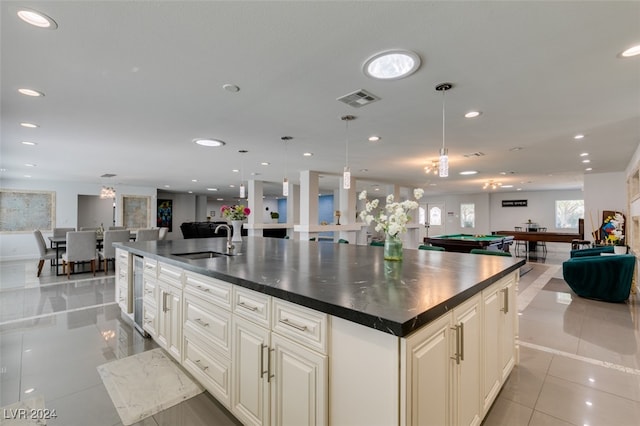 kitchen with a kitchen island with sink, billiards, sink, and pendant lighting