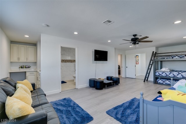 bedroom with light hardwood / wood-style floors, ceiling fan, and ensuite bath