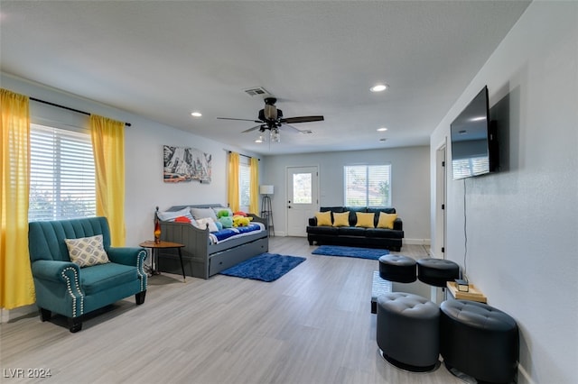 living room featuring light wood-type flooring and ceiling fan