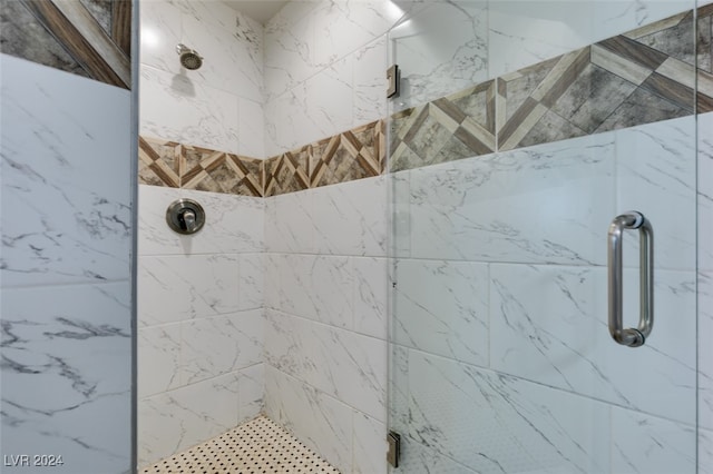 bathroom featuring a shower with shower door