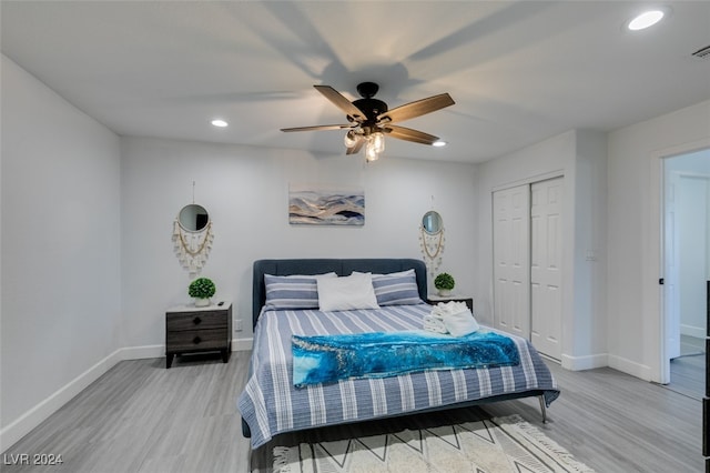 bedroom with a closet, hardwood / wood-style flooring, and ceiling fan