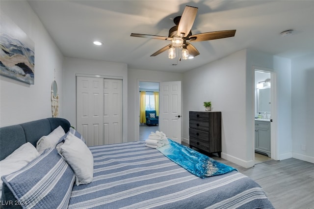 bedroom with ceiling fan, ensuite bath, a closet, and light wood-type flooring