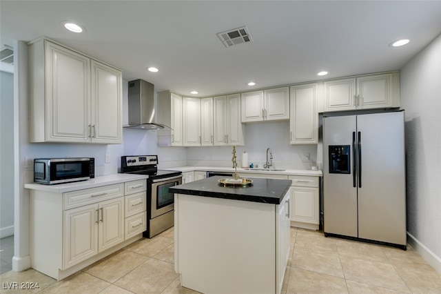 kitchen with light tile patterned flooring, a kitchen island, wall chimney range hood, appliances with stainless steel finishes, and sink