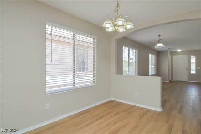 unfurnished room featuring hardwood / wood-style floors and a notable chandelier