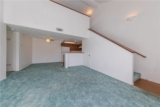 unfurnished living room featuring ceiling fan, beam ceiling, carpet flooring, and high vaulted ceiling