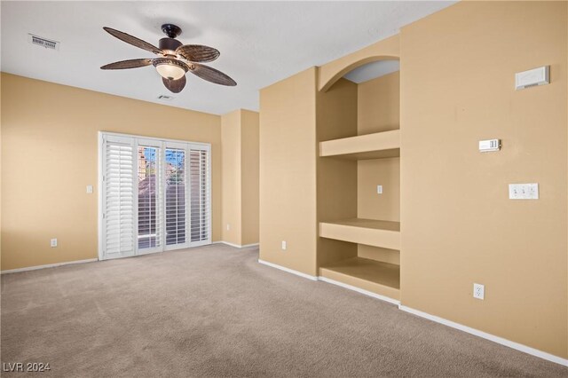 unfurnished room with ceiling fan and carpet