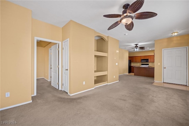 unfurnished living room featuring light colored carpet, built in features, and ceiling fan