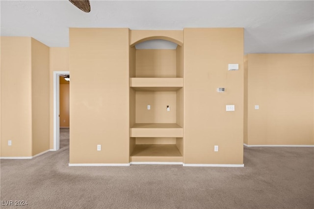 interior space featuring ceiling fan, carpet, and built in features