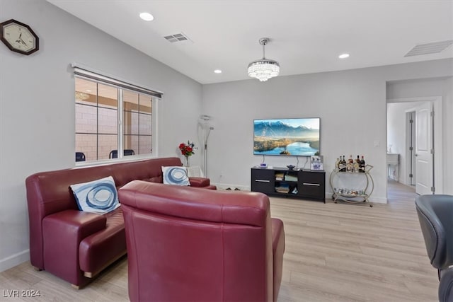 living room featuring light wood-type flooring and a chandelier