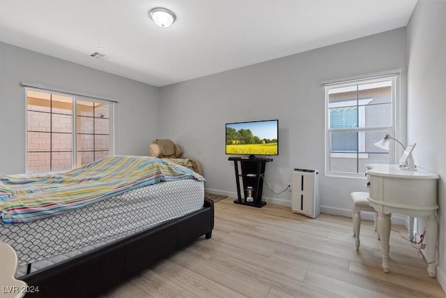 bedroom featuring light hardwood / wood-style flooring and multiple windows