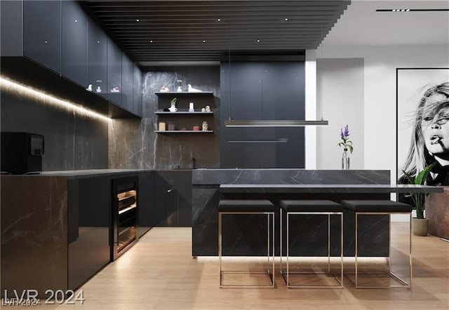 bar featuring backsplash and light hardwood / wood-style floors