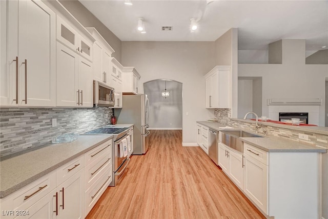 kitchen with backsplash, white cabinetry, sink, and appliances with stainless steel finishes