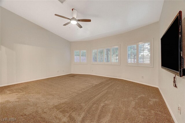 carpeted empty room featuring ceiling fan and vaulted ceiling