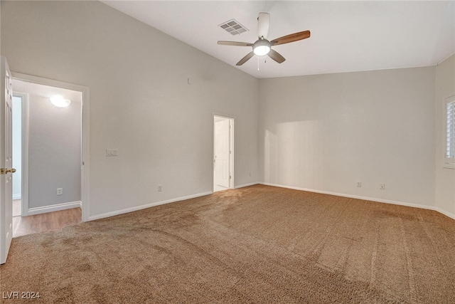 carpeted spare room with ceiling fan and lofted ceiling