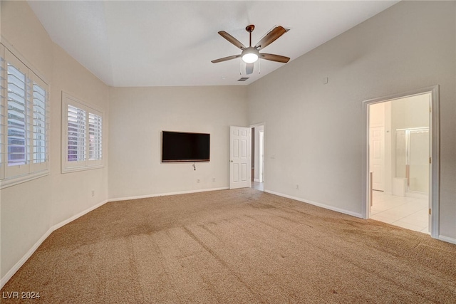 unfurnished living room featuring ceiling fan, light colored carpet, and lofted ceiling