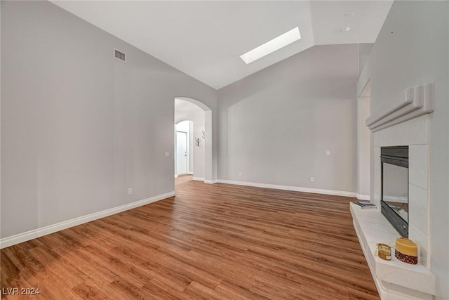 unfurnished living room with a fireplace, wood-type flooring, and lofted ceiling