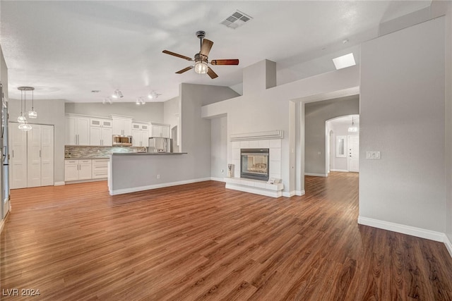 unfurnished living room featuring a fireplace, hardwood / wood-style flooring, ceiling fan, and lofted ceiling