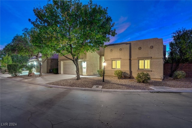 pueblo revival-style home featuring a garage