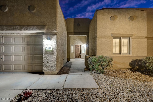 exterior entry at dusk with a garage