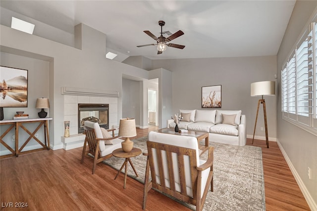 living room featuring a fireplace, wood-type flooring, ceiling fan, and lofted ceiling