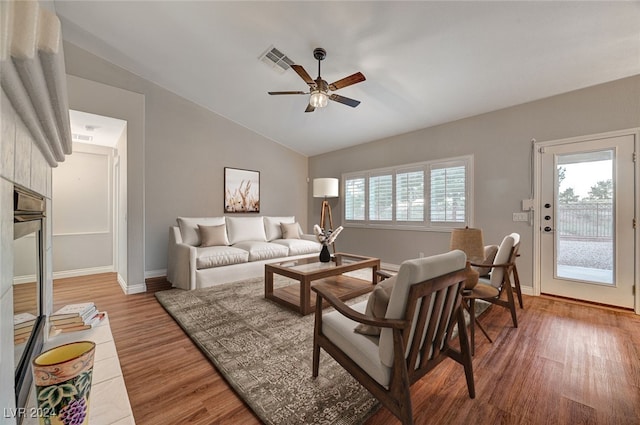 living room featuring hardwood / wood-style floors, ceiling fan, and lofted ceiling