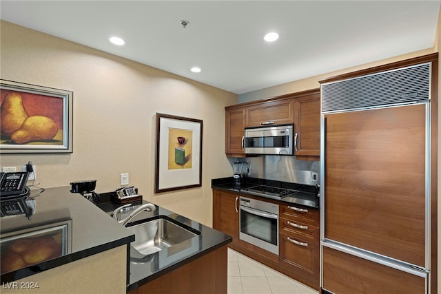 kitchen featuring stainless steel appliances, light tile patterned flooring, and sink