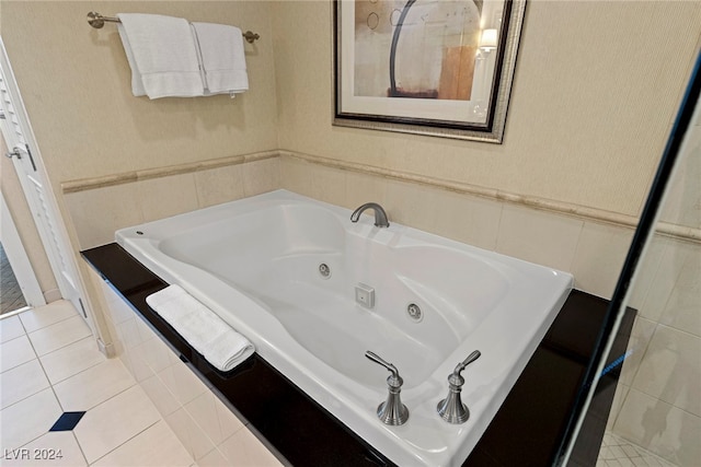 bathroom with tile patterned flooring and tiled tub