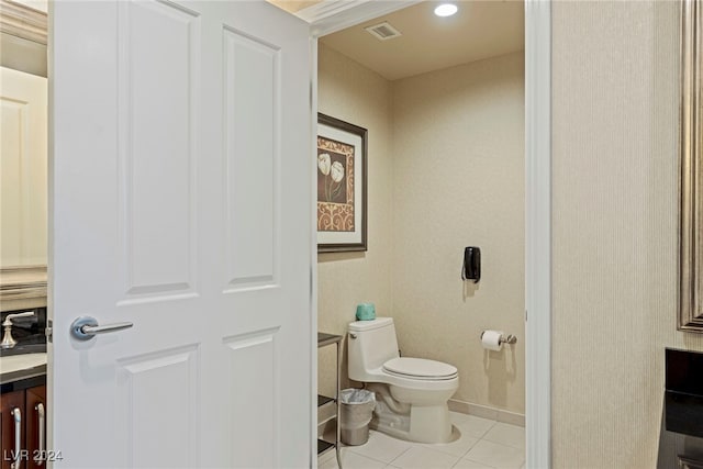 bathroom with toilet, sink, and tile patterned flooring