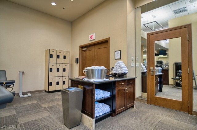 carpeted home office with a high ceiling