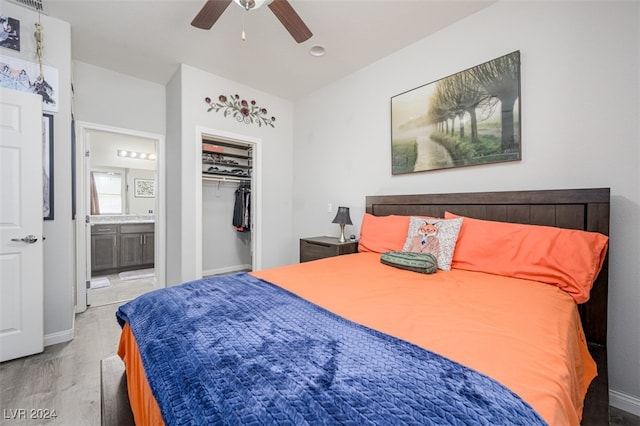 bedroom with ensuite bath, ceiling fan, a closet, and light wood-type flooring