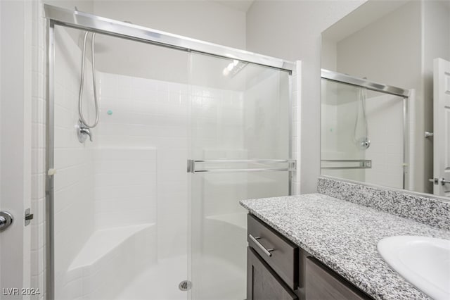 bathroom featuring vanity and a shower with door