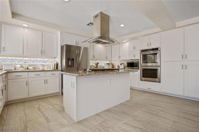 kitchen with island exhaust hood, stainless steel appliances, a kitchen island, and white cabinets