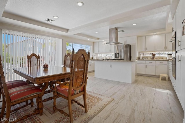 dining area featuring a raised ceiling