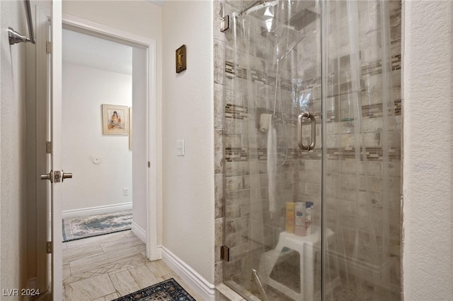 bathroom with a shower with door