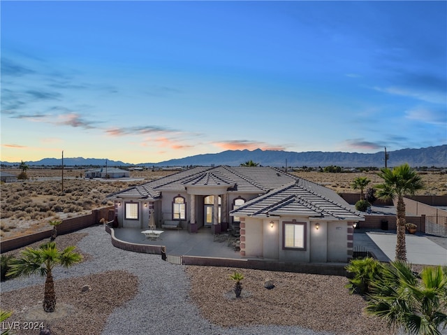 view of front of home with a mountain view and a patio area