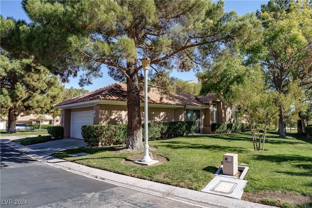 view of front of house featuring a garage, driveway, stucco siding, a tile roof, and a front yard