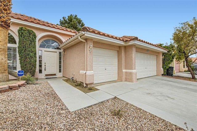 exterior space featuring a tile roof, an attached garage, concrete driveway, and stucco siding