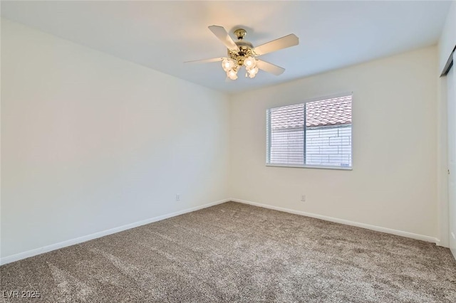 carpeted spare room with a ceiling fan and baseboards