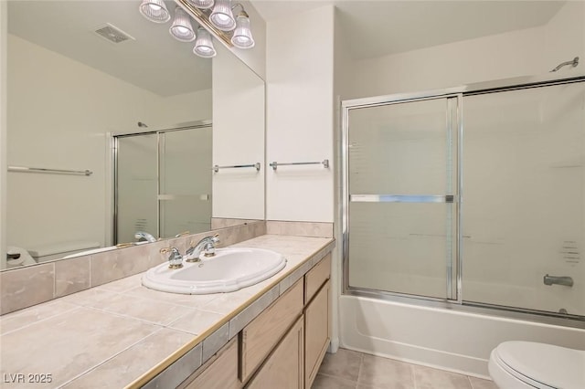 bathroom with tile patterned flooring, visible vents, toilet, shower / bath combination with glass door, and vanity