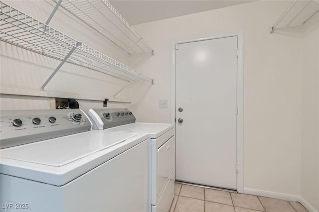 washroom featuring laundry area, light tile patterned flooring, baseboards, and washer and clothes dryer