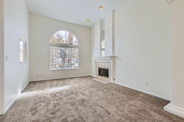 unfurnished living room featuring baseboards, carpet, and a fireplace