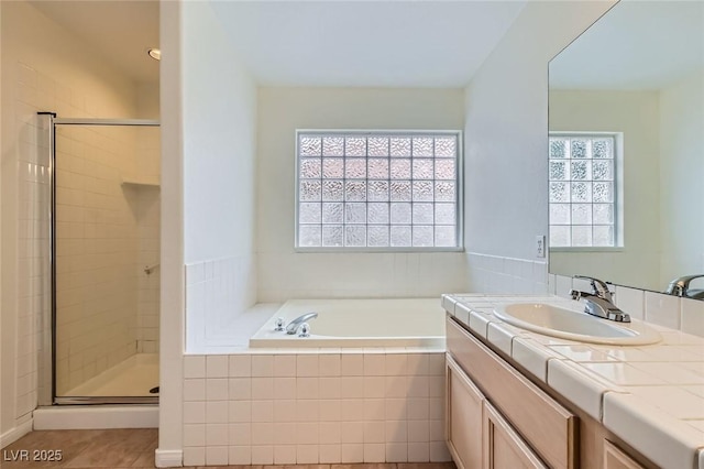 full bathroom featuring a wealth of natural light, a garden tub, and a stall shower