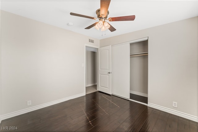 unfurnished bedroom with ceiling fan, a closet, and dark wood-type flooring