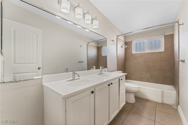 full bathroom with vanity, vaulted ceiling, tile patterned flooring, toilet, and tiled shower / bath