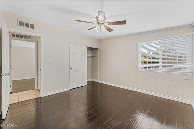 unfurnished bedroom featuring a closet, dark hardwood / wood-style floors, and ceiling fan