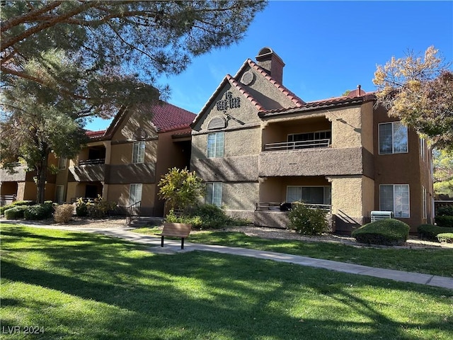 2200 S Fort Apache Rd Unit 2133, Las Vegas, NV 89117 - view of front of property featuring a chimney, stucco siding, a front lawn, and a tiled roof