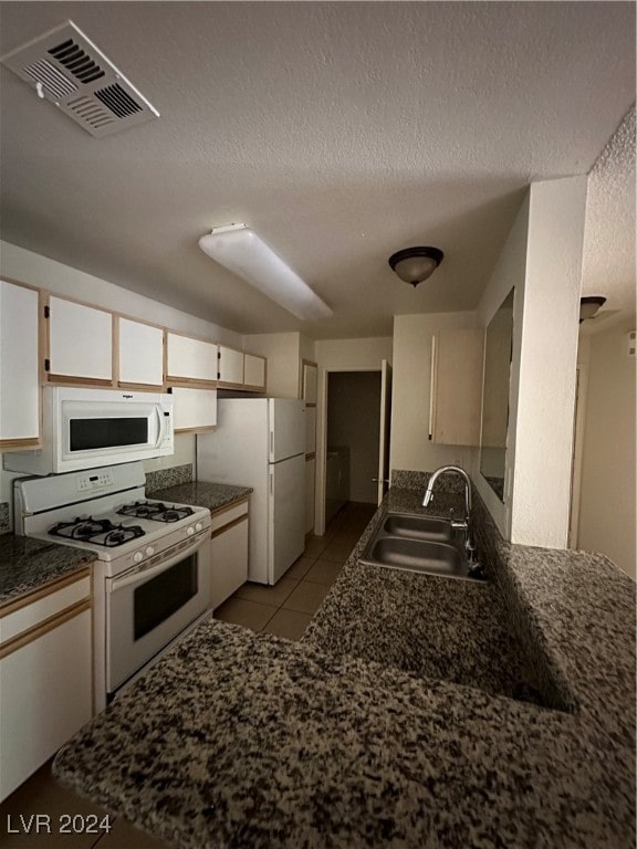 kitchen featuring white cabinets, a textured ceiling, white appliances, and sink